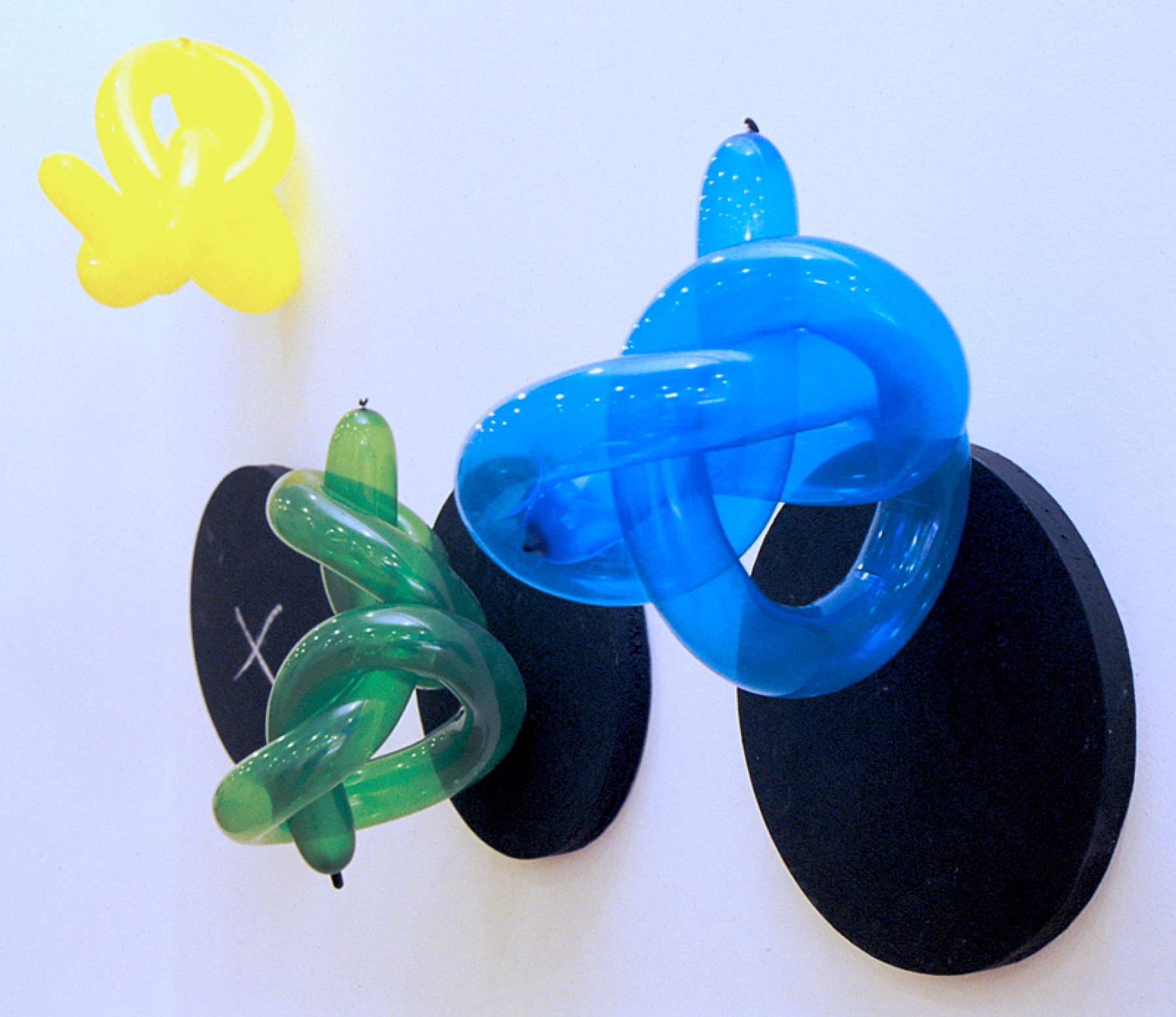 Twisted balloon sculptures on black discs