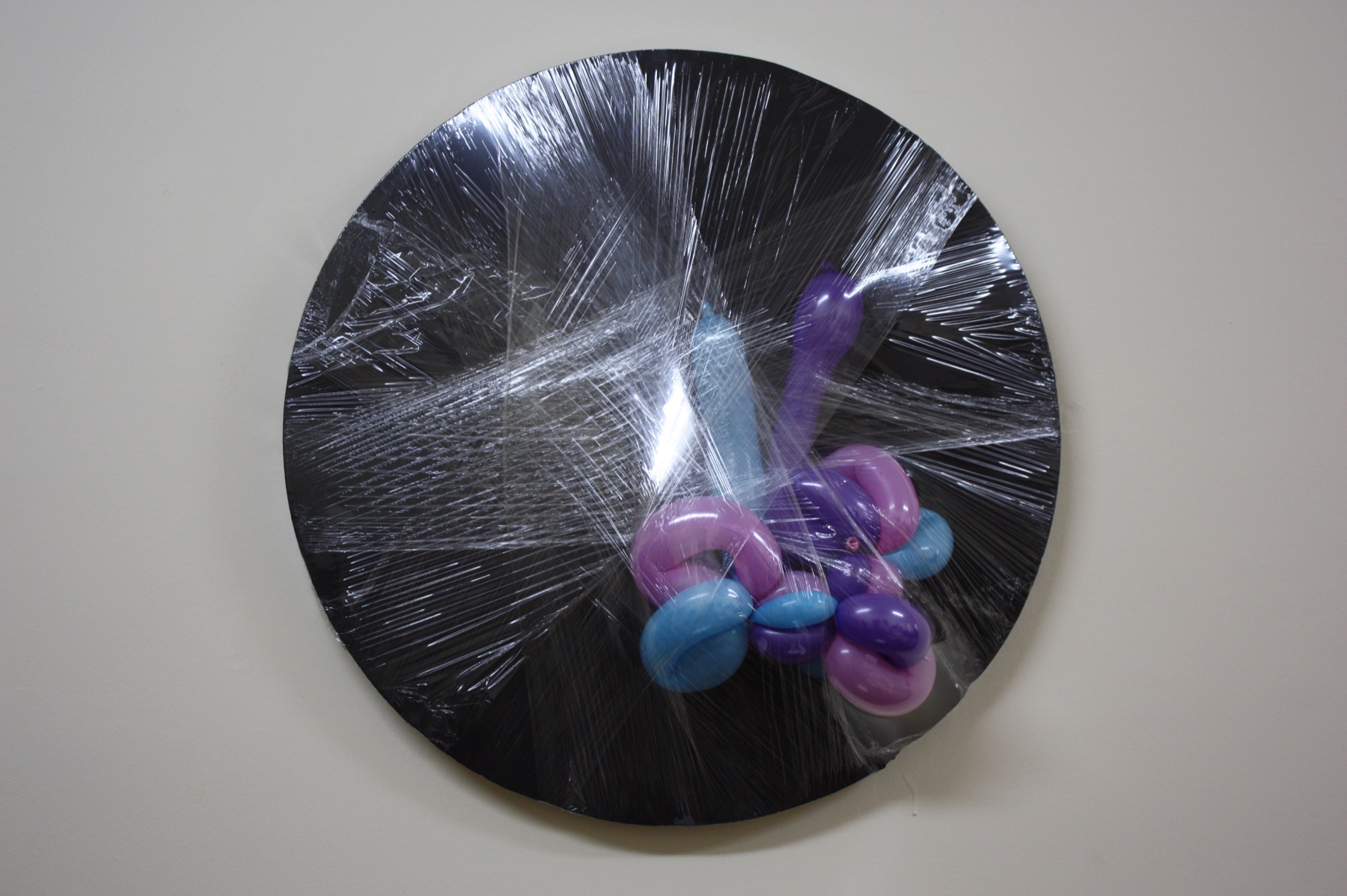 Balloon and stretched film over a black disc