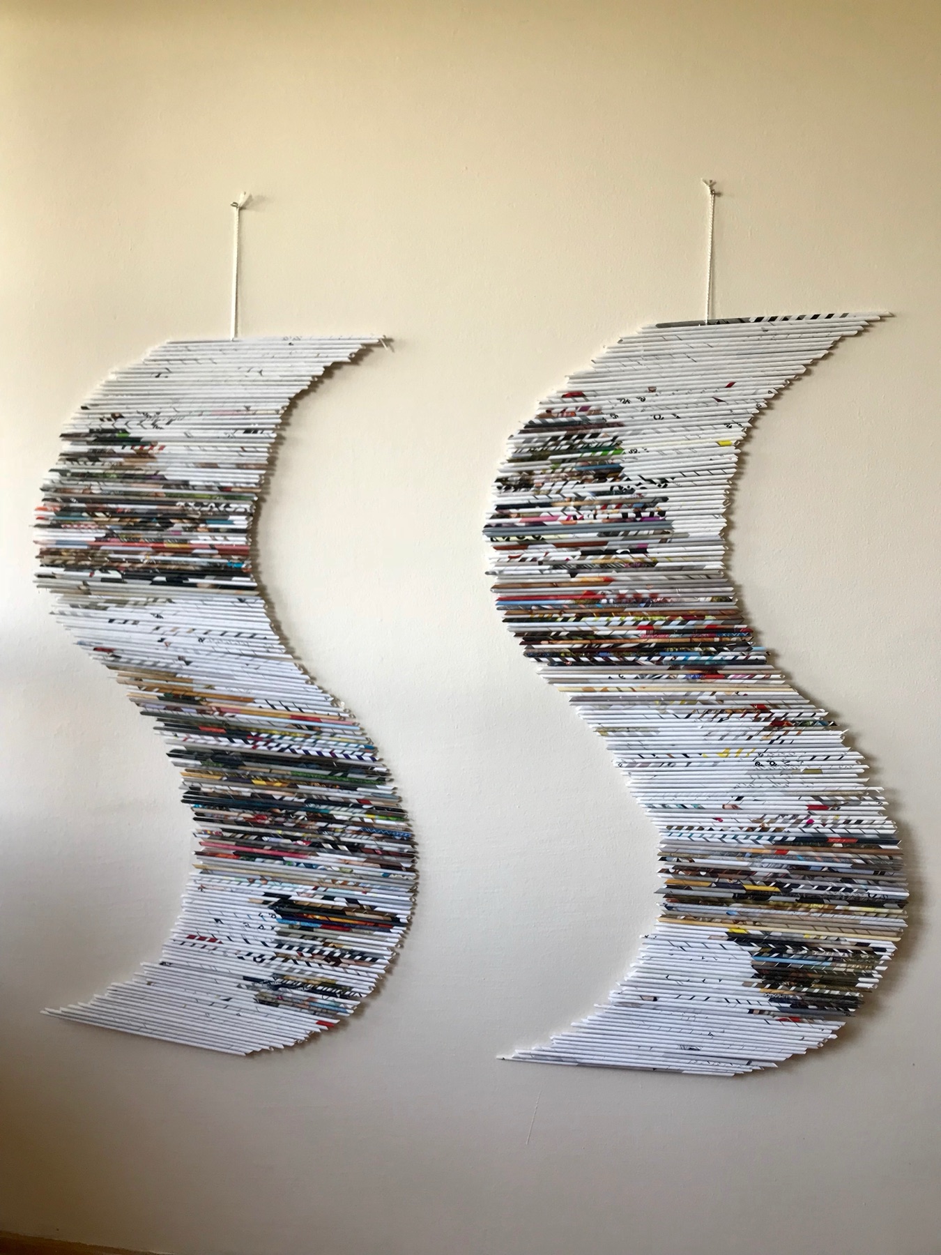 Two S-shaped rolled-paper wall sculptures